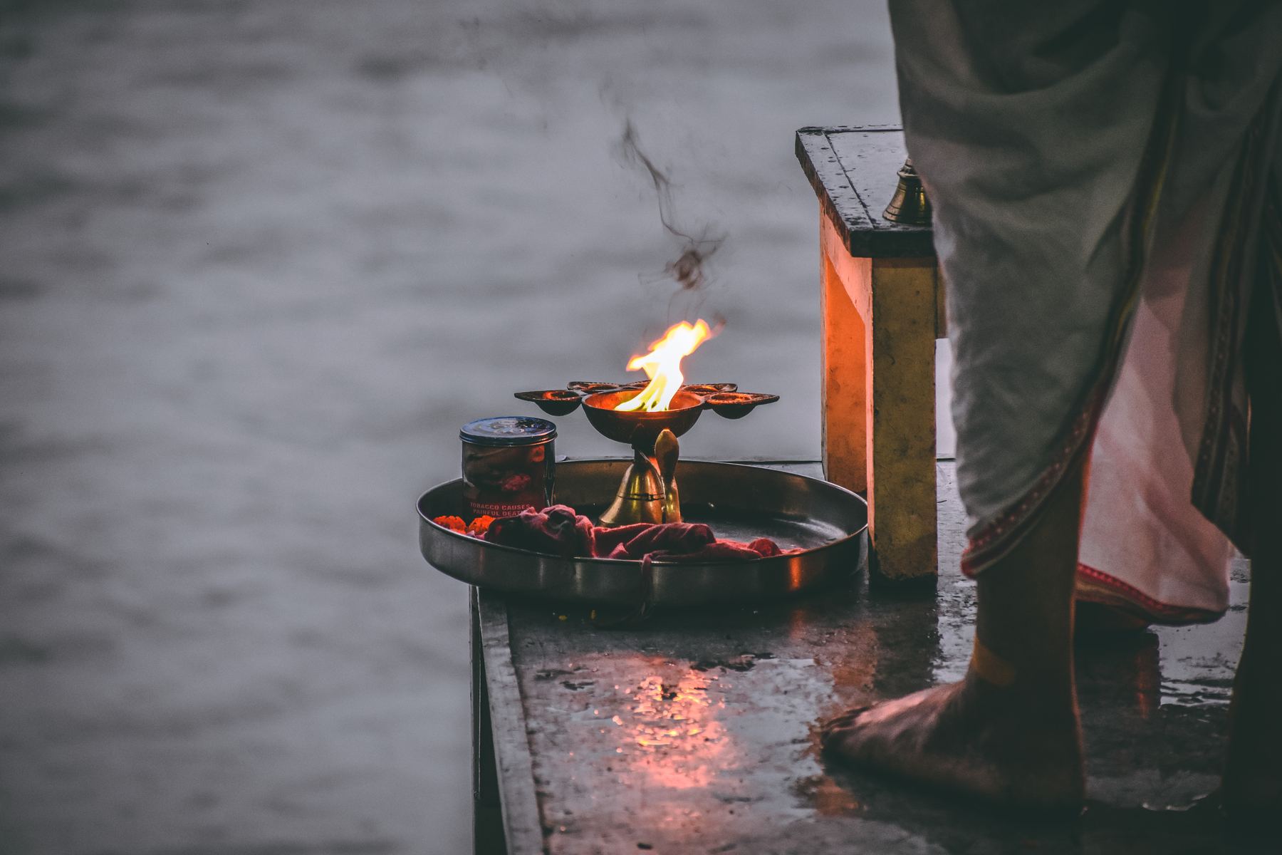 Fire ceremony tray lit at the edge of the Ganga during evening Aarti